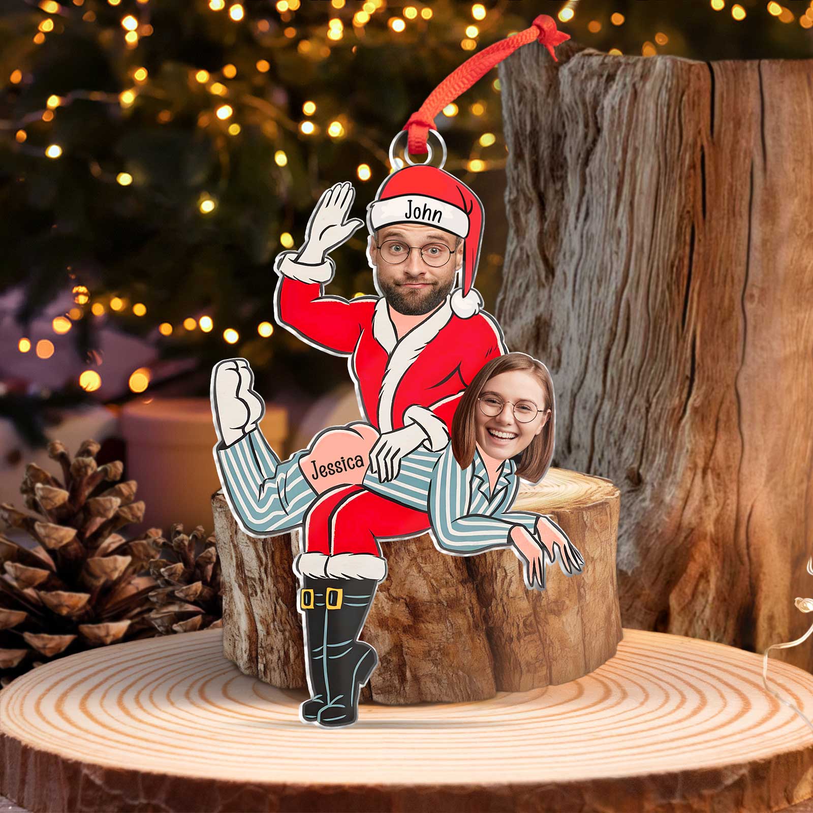 Cheeky personalized couple's Christmas ornament hanging on a festive tree branch with warm holiday lighting