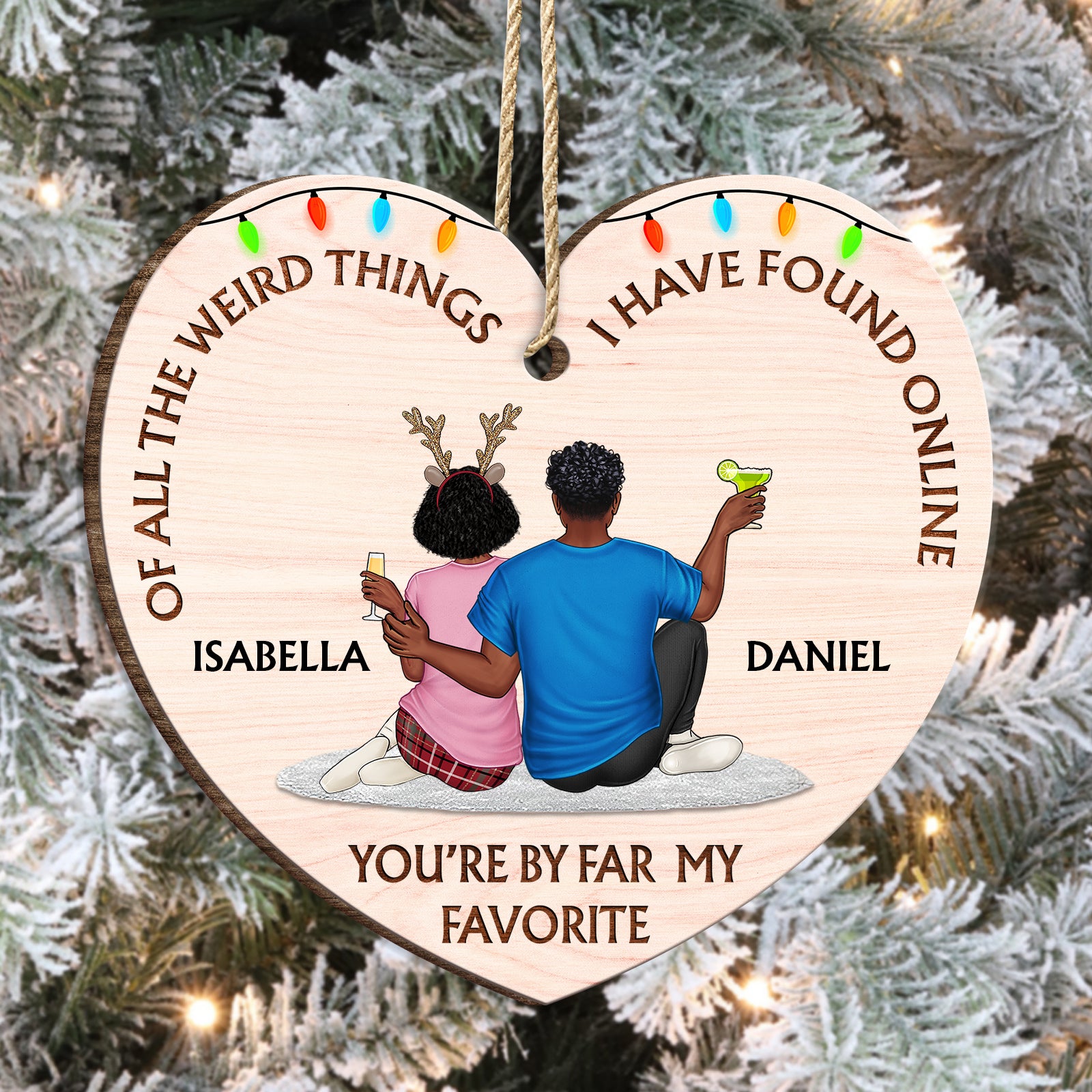 A custom wooden couple's ornament hanging on a lit Christmas tree, highlighting the high-quality wood grain and vibrant print