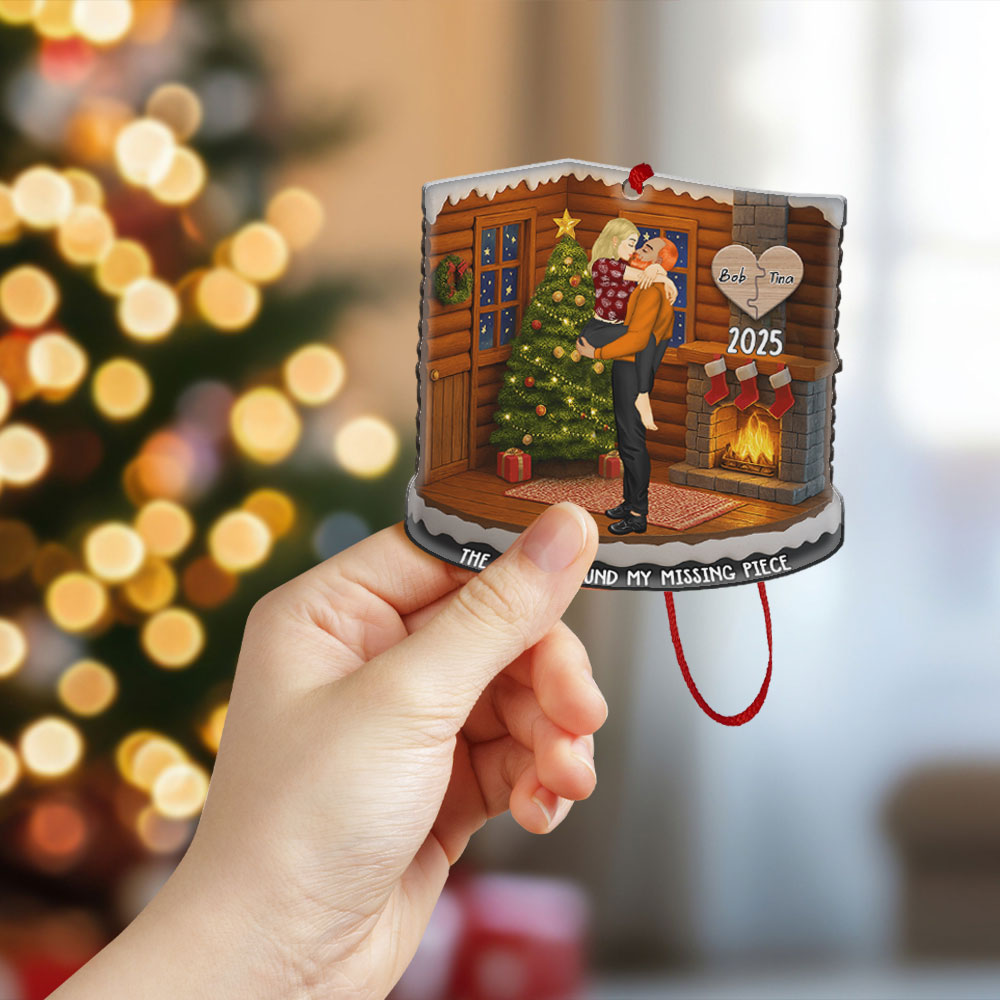 Customized missing piece ornament hanging on a Christmas tree with a festive red ribbon and warm holiday lights