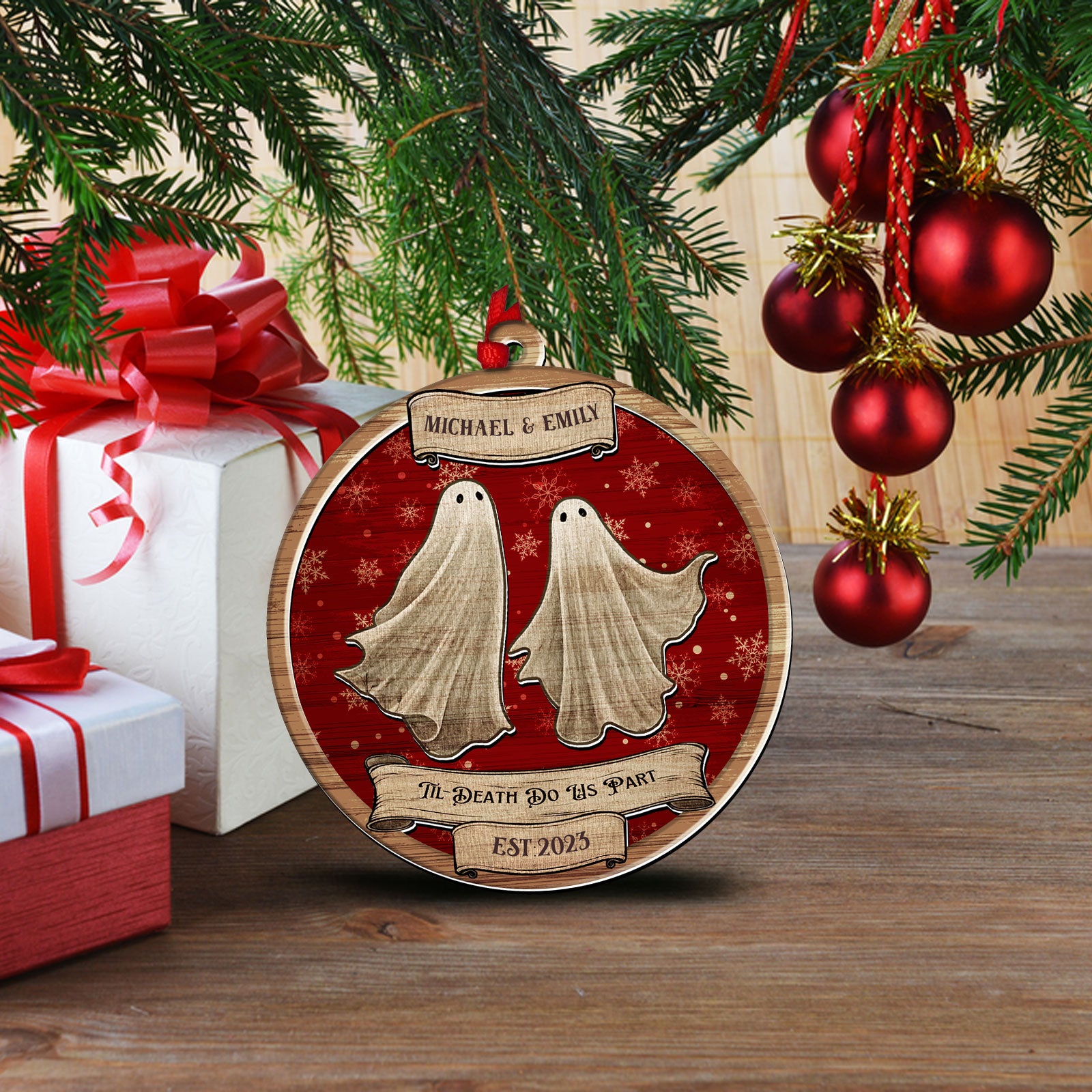 Personalized romantic boo ornament hanging on a blurry Christmas tree background with gift boxes and warm lights